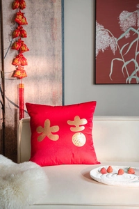 Detail of red velvet pillow cover featuring gold foil Chinese characters and orange motif