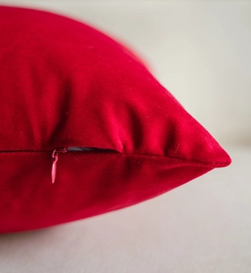 Close-up of red velvet pillow cover showing the high-quality invisible zipper detail