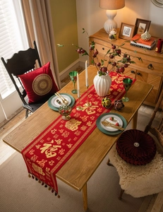 Detail of red Chinese New Year table runner with gold Fu character and elegant tassels