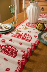 Close-up of red and beige jacquard table runner with lion dance and Fu character pattern
