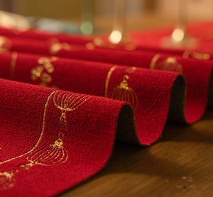 Macro shot of red festive table runner with golden embroidery and jacquard texture
