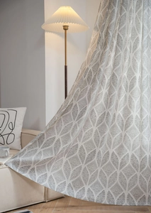 Détail du motif de feuilles géométriques gris sur le rideau blanc semi-transparent