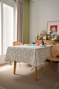Detail of elegant rectangular linen tablecloth with geometric leaf pattern in home setting