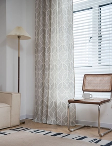 Détail du rideau moderne beige avec motif de feuilles géométriques gris et texture lin