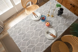 Close-up of geometric grey pattern on white cotton linen tablecloth on a dining table
