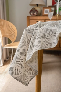 Detail of linen tablecloth featuring gray geometric diamond patterns on beige fabric