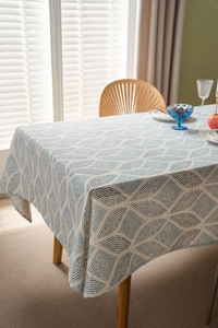Detailed texture of blue geometric linen tablecloth on a rustic wooden dining table