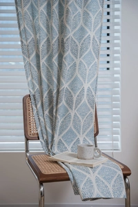 Détail du rideau en coton et lin avec des motifs de feuilles géométriques bleues