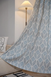Détail du motif géométrique bleu sur le tissu de rideau crème semi-occultant