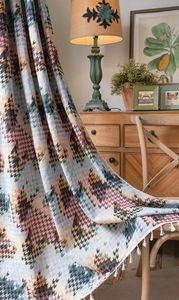 Detail van kleurrijk houndstooth jacquard gordijn met elegante witte decoratieve kwastjes