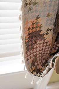 Detail van geweven houndstooth jacquard wandtapijt met crème franje afwerking