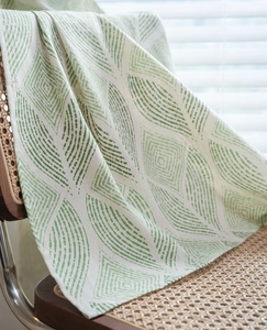 Détail du motif de feuilles sur le tissu du rideau crème avec une texture en lin