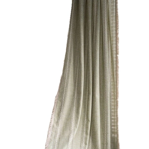 Grass green embroidered curtain with white vertical stripes and fringed edge on white backdrop