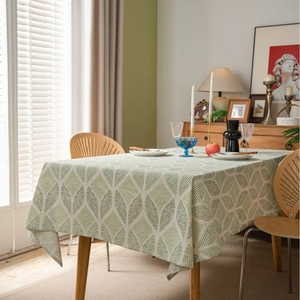 Linen cotton tablecloth featuring green geometric leaf patterns in a Nordic dining setting