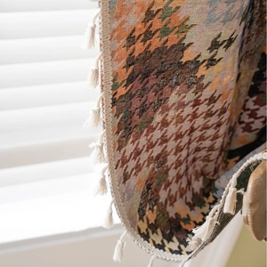 Kleurrijke decoratieve plaid met houndstooth-patroon en elegante witte franje kwastjes