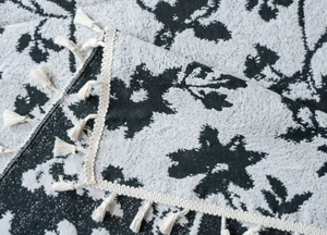 Dettaglio della tenda jacquard rosa con eleganti nappe e texture intrecciate