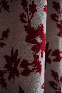 Dettaglio macro del tessuto a trama spessa con motivo jacquard a rose rosse e grana