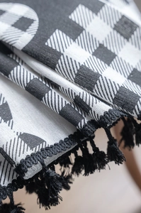 Dettaglio del tessuto per tende a scacchi con nappe nere e trama intrecciata