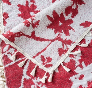 Dettaglio del tessuto jacquard a foglie d'acero rosso e bianco con eleganti frange