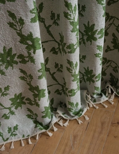 Dettaglio del tessuto jacquard a rose con motivi a foglie verdi e piccole nappe