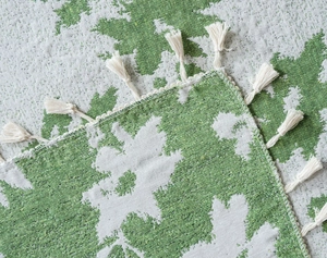 Dettaglio del tessuto jacquard per tende rosa verde e bianco con nappe decorative sui bordi