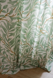 Close-up of linen fabric texture with green leaf print and natural fiber details