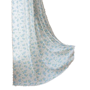 Rideau blanc avec motifs de fleurs bleues et détails de franges à pompons élégants