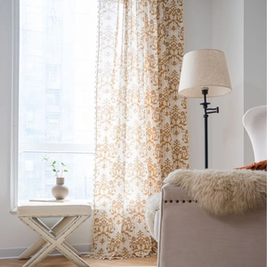 Damask pattern khaki curtains with small ball tassels and soft semi-sheer natural lighting