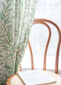 Close-up of green plant print on linen texture curtain with natural sunlight detail