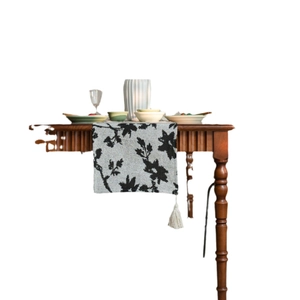 Floral jacquard table runner with grey branch patterns and white decorative tassels