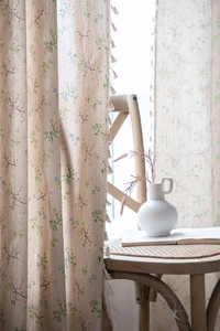 Detail of floral linen curtain with white fringe tassels and natural pastoral print