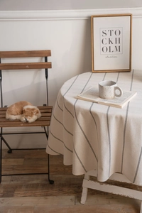 Detailed texture of round cotton linen tablecloth with minimalist black vertical stripes