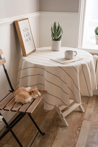 Detailed texture of beige linen tablecloth with black stripes and elegant drape