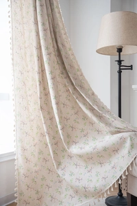Close-up of floral print linen curtain with tassel fringe details in pastoral style