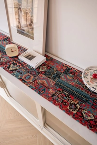 Detailed view of bohemian jacquard table runner with red geometric weave texture