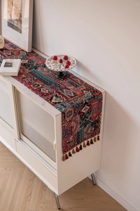 Close-up of bohemian table runner with colorful geometric weave and handmade tassels