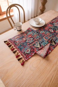 Macro detail of bohemian woven table runner with geometric patterns and fringe tassels