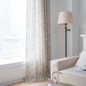 Floral print curtains with pom-pom fringe in soft green and blue for home decor
