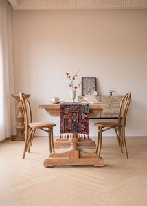 Detailed close-up of ethnic style table runner with intricate jacquard and decorative tassels