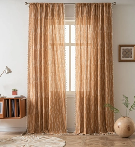 Detail of yellow Bohemian curtain with white wavy lines and white tassel edge