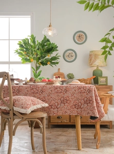 Detail of vintage pink rose jacquard tablecloth with matching tasseled pillows