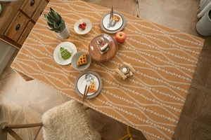 Flat lay of vintage orange floral tablecloth featuring woven linen texture and patterns