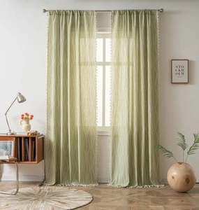 Detail of light green floral curtain with white vine patterns and elegant tassel trim fringe