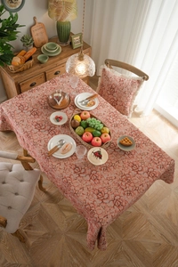 Macro shot of thick jacquard tablecloth showing coral pink floral patterns and textured fabric