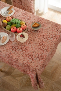 Close-up detail of coral pink floral jacquard fabric with rose patterns on table cloth