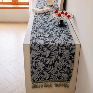 Nordic style dark blue table runner with beige leaf patterns and decorative tassels