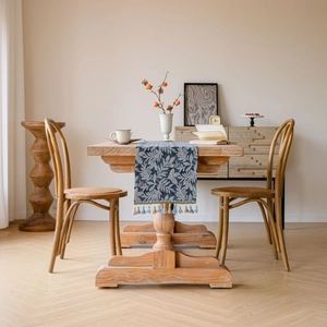 Nordic blue leaf pattern table runner with tassel on a natural wooden dining table