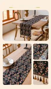 Detailed view of floral jacquard table runner with vintage fringes on black fabric