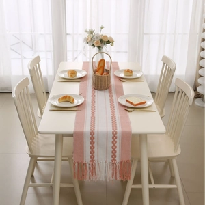 Pink and white woven table runner with jacquard geometric pattern and tassels
