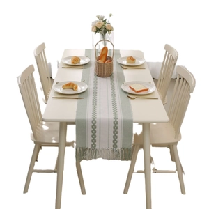 Green and white striped jacquard table runner with textured weave and tassels
